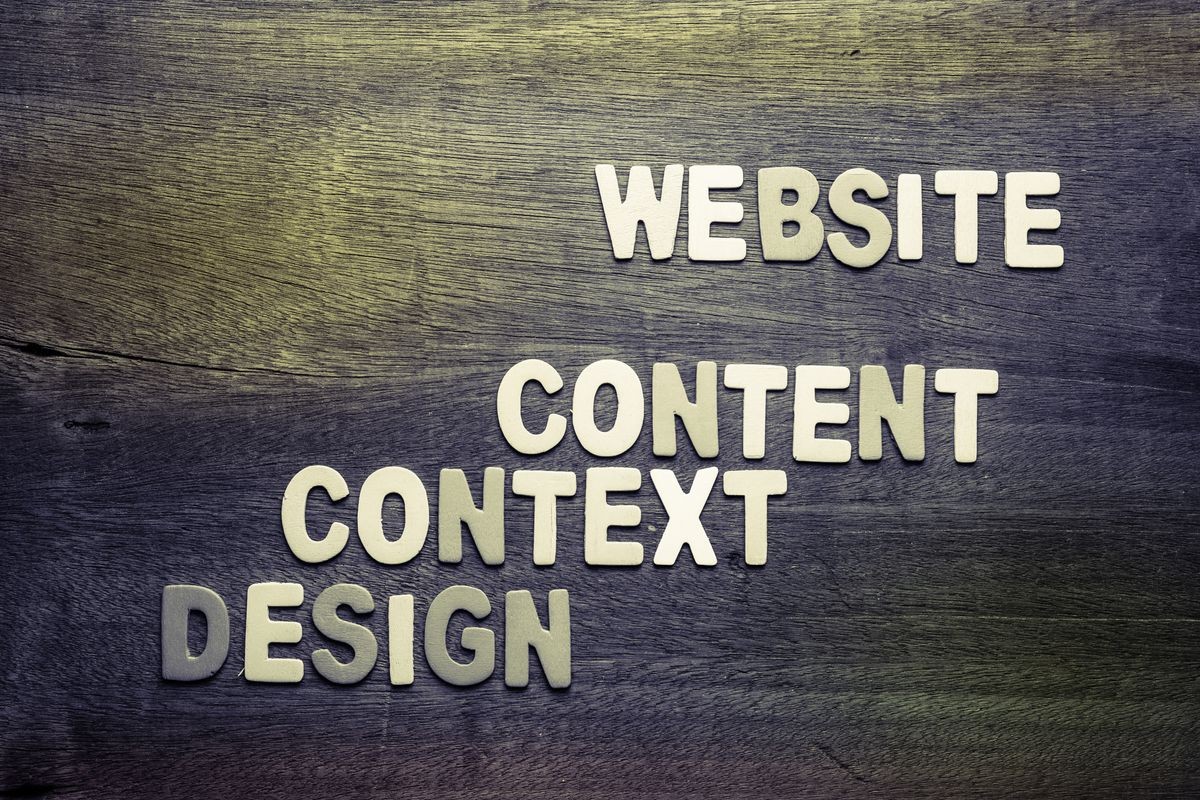 Website Creation concept with Content, Context, and Design text on wood background